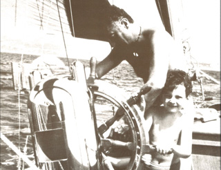 Gianni Agnelli at the helm of his sailing boat with Edoardo as a young child