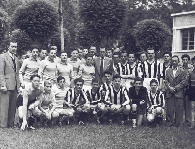 Posing with a football team at the Headquarters of the “Società Agricola Operaia di M.S. “ of Villar Perosa.